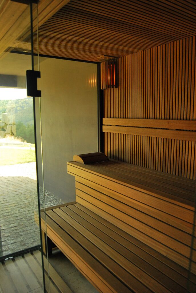 Sauna fińska z drewnianymi ławami i szklanymi drzwiami